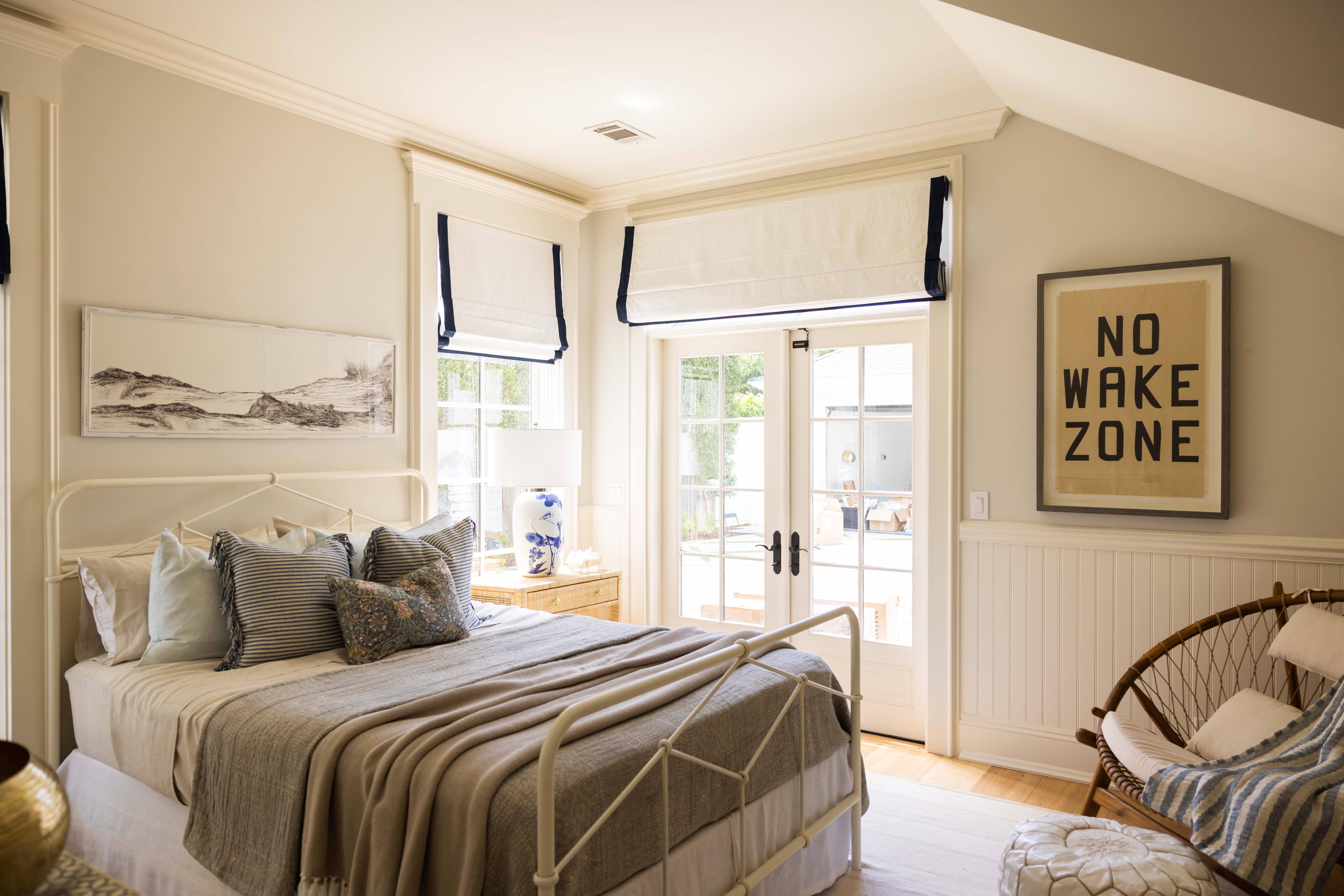 Bedroom with French doors and coastal art, Seaside Retreat
